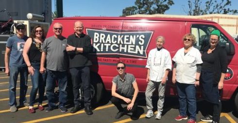 Volunteers from Bracken's Kitchen, OFRF staff, and volunteer chefs in front of Bracken's Kitchen van filled with donated food from luncheon