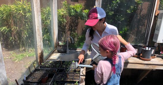 brise and her daughter watering seedlings in the greenhouse