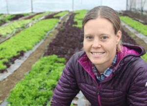 farmer Maggie Dungan in front of her lettuce crops