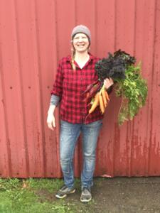 April Thatcher, farmer and board president, holding carrots