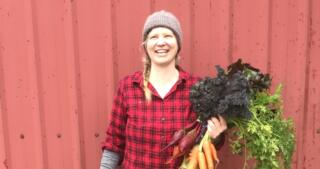 April Thatcher, farmer and OFRF Board President, holding carrots