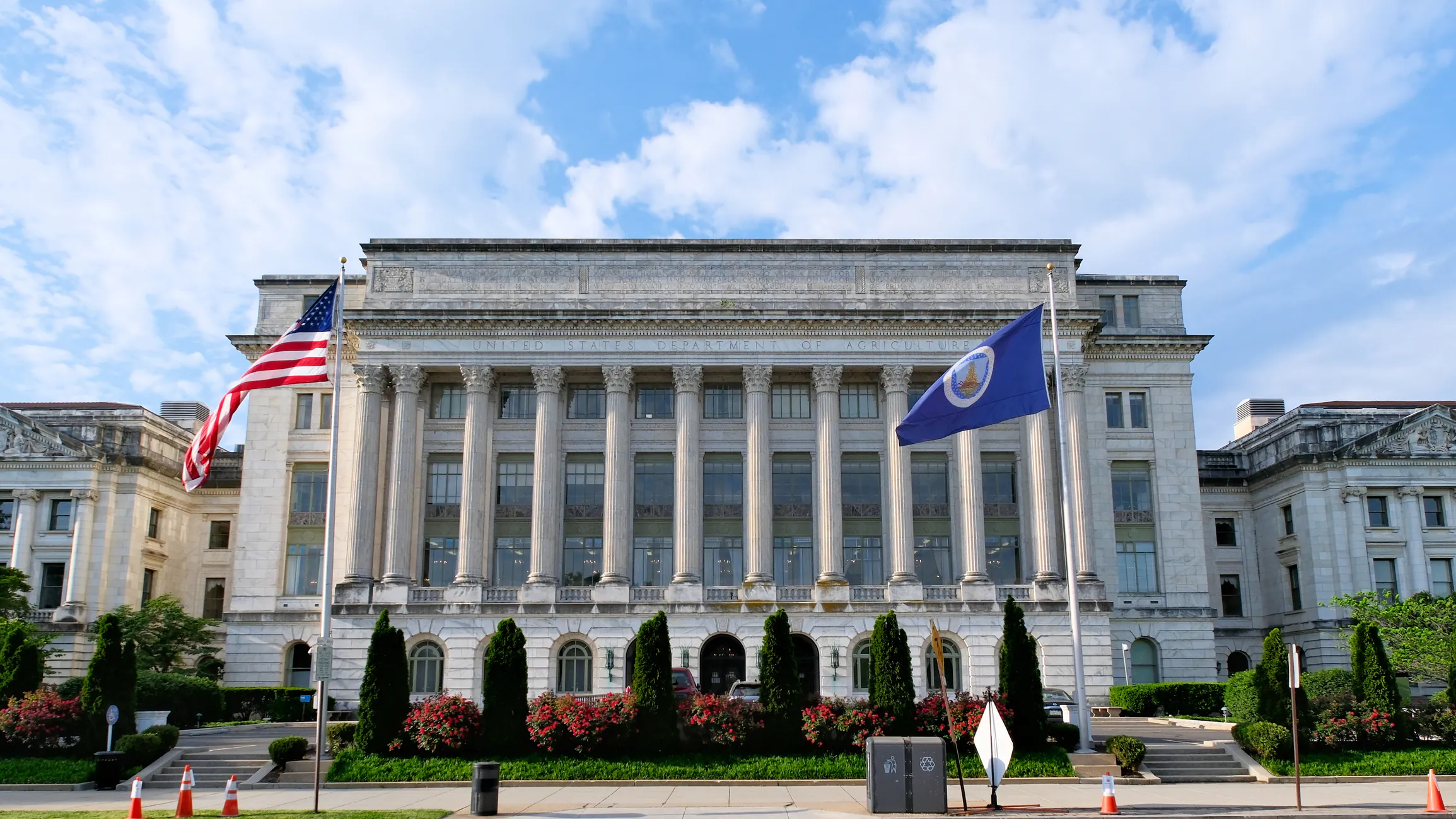 photo of USDA building in Washington DC with a blue and cloudy sky behind it.