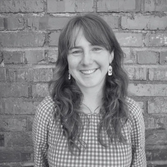 headshot of Annika Sampson in black & white against brick wall