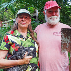 Kathy and Rob Vass_Makili Farms_2026 Farmers Kathy Vass, holding a chicken, and Rob Vass, holding a shovel