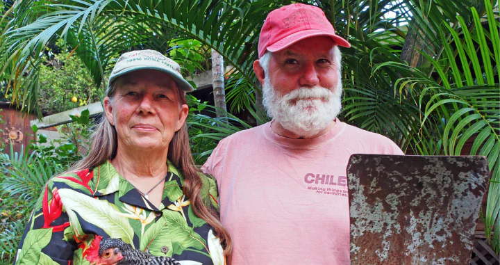 Farmers Kathy Vass, holding a chicken, and Rob Vass, holding a shovel