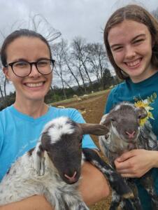 Farmers Amy and Madeline Lucas pose with their lambs.