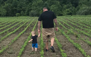 Alan Wilson walks through a field with his kid.