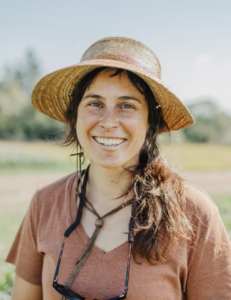 Ellie Costello of Trust Land Farm in Montana smiling and wearing a sun hat
