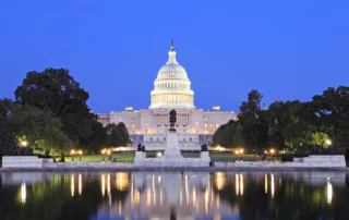 The capital building at dusk reflected in the reflecting pool.
