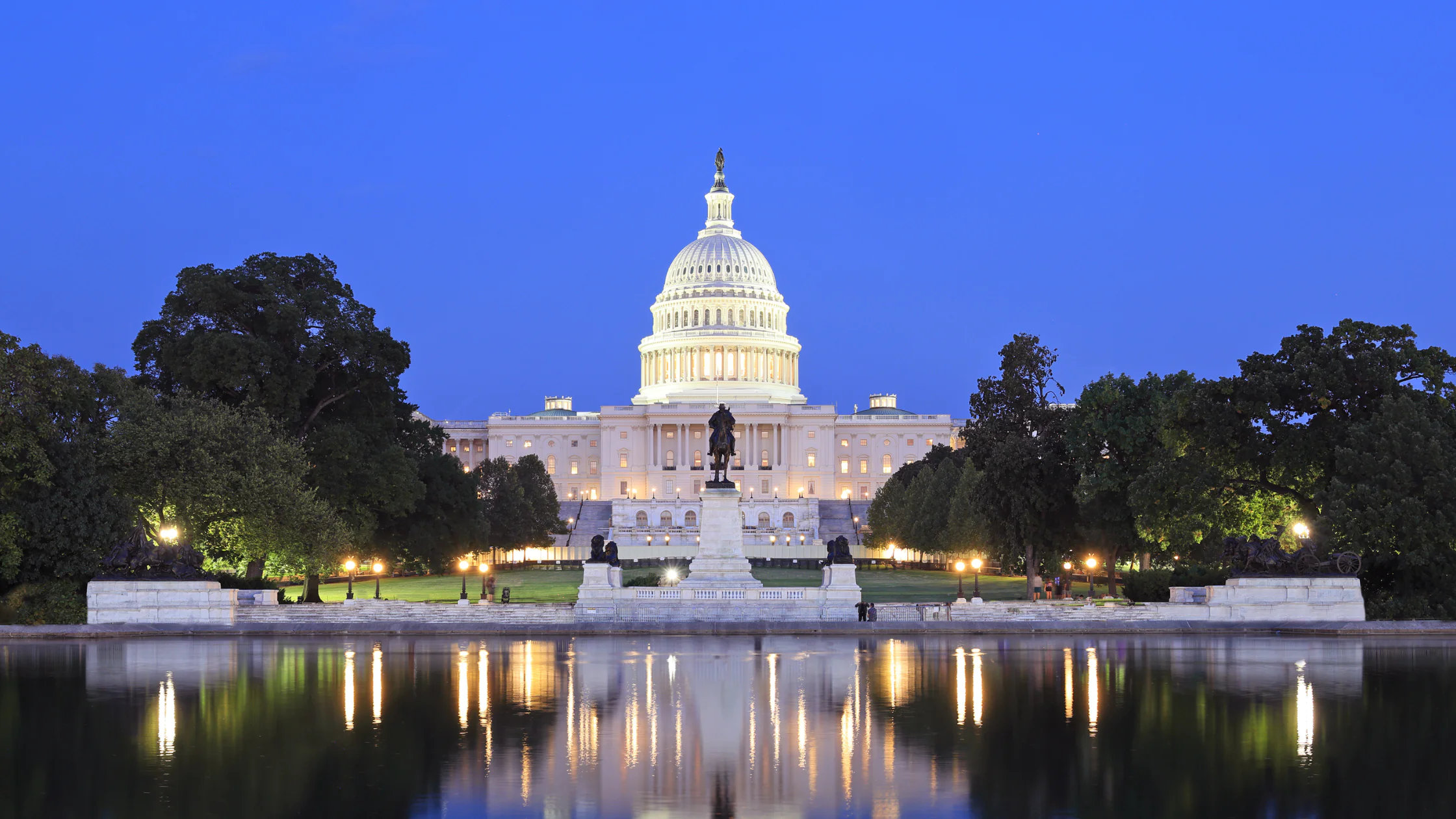 The capital building at dusk reflected in the reflecting pool.