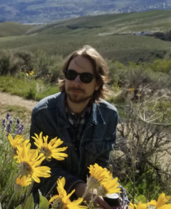Robert Orpet, Oregon State University Assistant Professor of Entomology Robert Orpet, Assistant Professor of Entemology at Oregon State University, outdoors among yellow wildflowers.