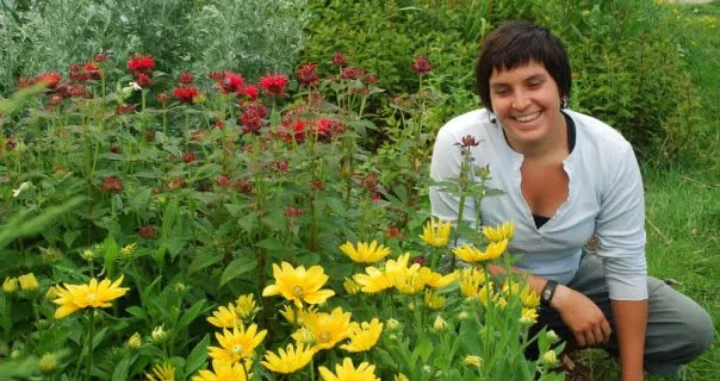 OFRF Board Member Carrie-Anne Palmeri smiling near a bed of flowers.