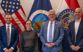 Jesse Womack (Policy Specialist, NSAC), Brise Tencer (Executive Director, OFRF), Richard Fordyce (USDA Under Secretary for Farm Production and Conservation), and Ben Bowell (Chief Programs Officer, Oregon Tilth) posing in front of USA and USDA flags during OTA's Organic Week 2026 in Washington, D.C.