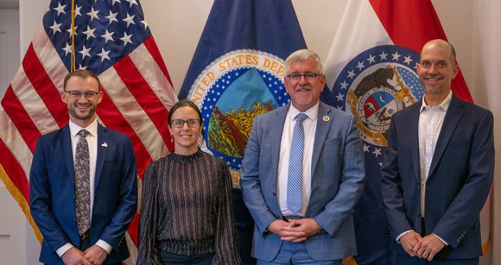 Jesse Womack (Policy Specialist, NSAC), Brise Tencer (Executive Director, OFRF), Richard Fordyce (USDA Under Secretary for Farm Production and Conservation), and Ben Bowell (Chief Programs Officer, Oregon Tilth) posing in front of USA and USDA flags during OTA's Organic Week 2026 in Washington, D.C.